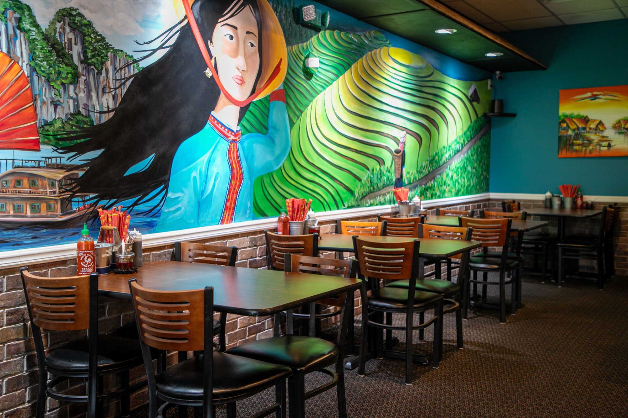 Hand-painted mural of a woman in a conical hat overlooking rice terraces
